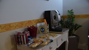 A buffet table with food items, a coffee machine, and a plant. - B&B The Queens (Foggia)