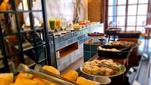 A buffet with various food items including bread, pastries, and a selection of drinks. -  Hot Beach Raízes (Olímpia)