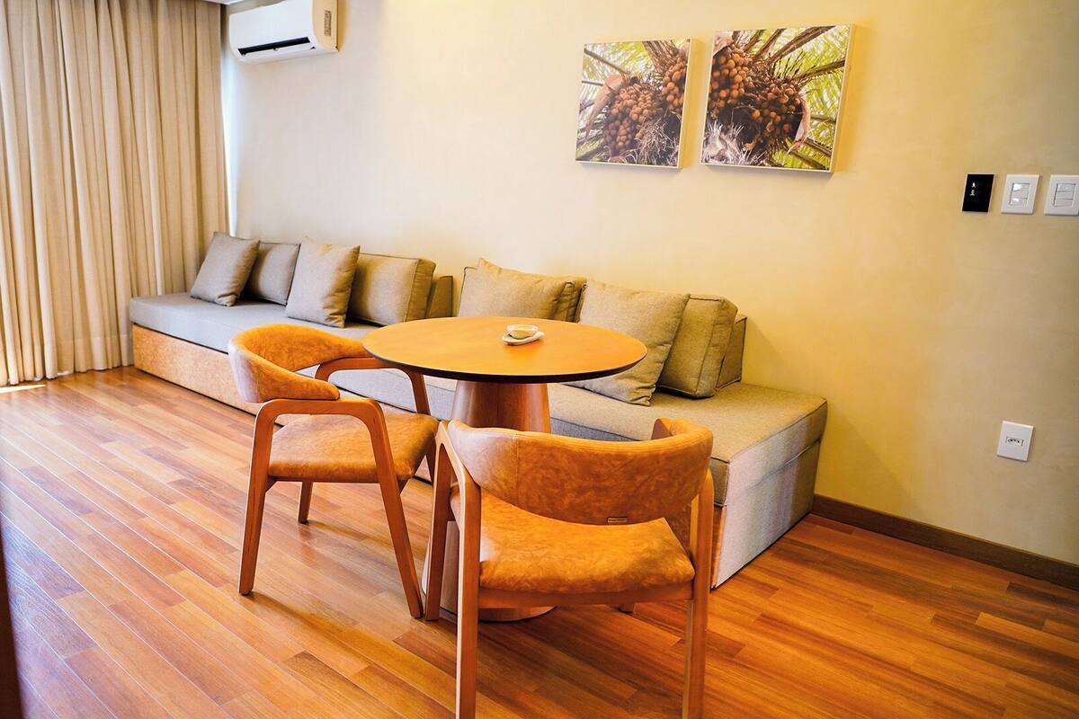 Ein modernes Wohnzimmer mit einer Couch, zwei Sesseln, einem Couchtisch und Holzböden.