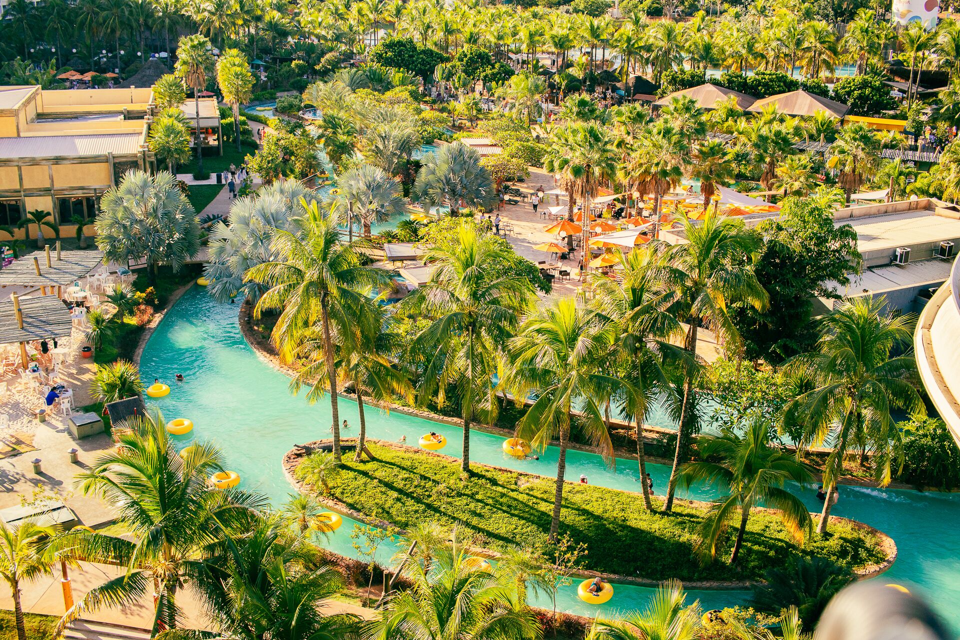 Ein Resort mit einem zentral gelegenen Pool, umgeben von Palmen und Sitzbereichen im Freien.