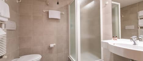 Une salle de bain moderne équipée de toilettes, d’un bidet et d’une douche à parois de verre.