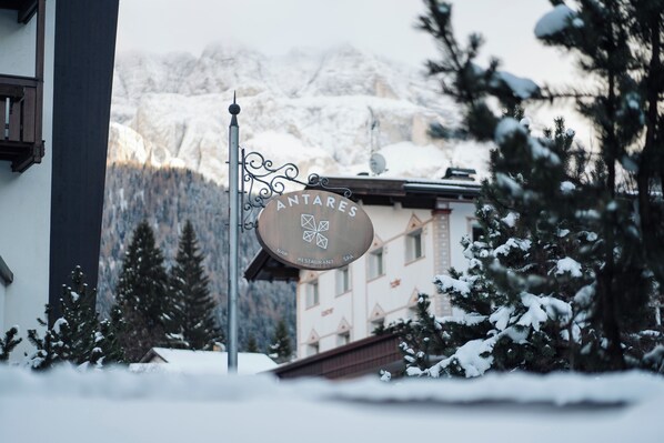 A sign for 'ANTARES BAR RESTAURANT SPA' with a mountainous backdrop.