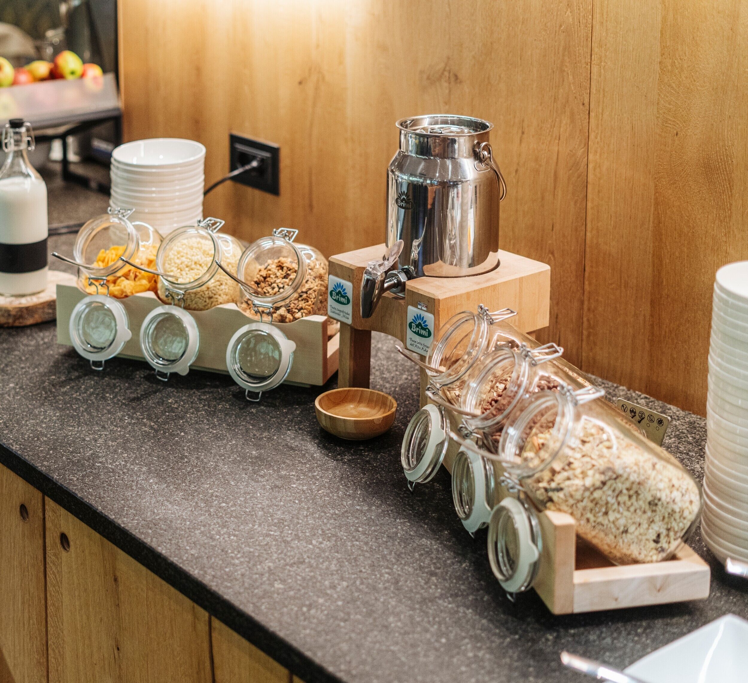 A buffet setup with various food containers and a coffee machine.