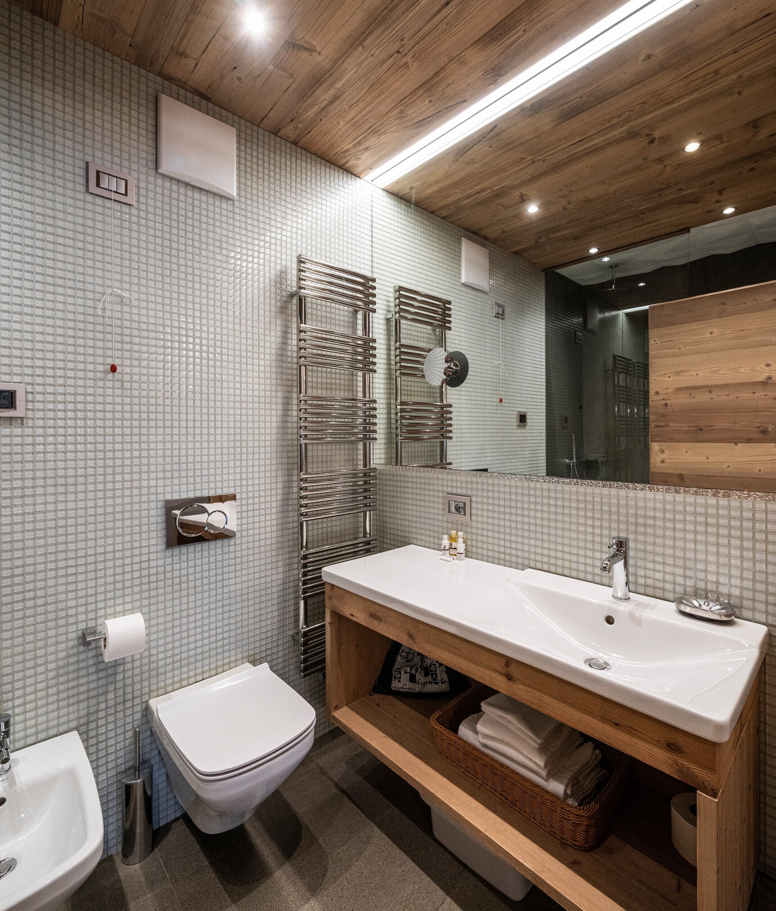 Un baño moderno con lavamanos blanco, inodoro y zona de ducha.