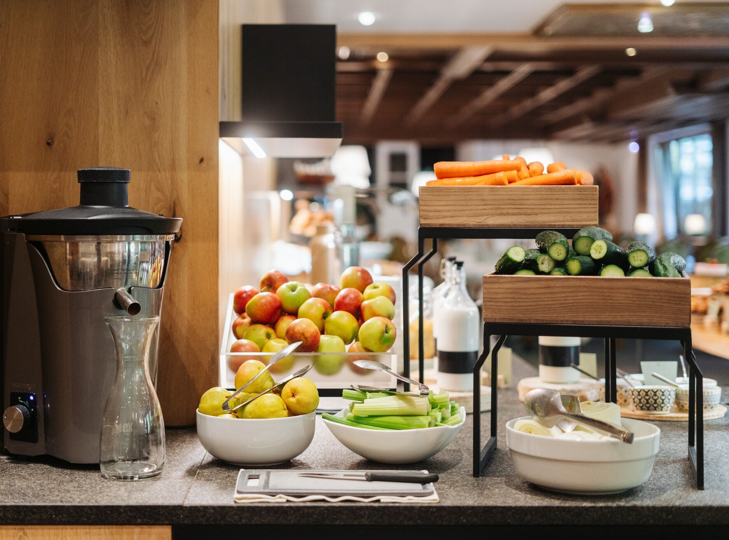 A kitchen counter with various fruits and vegetables, a coffee maker, and a milk dispenser.