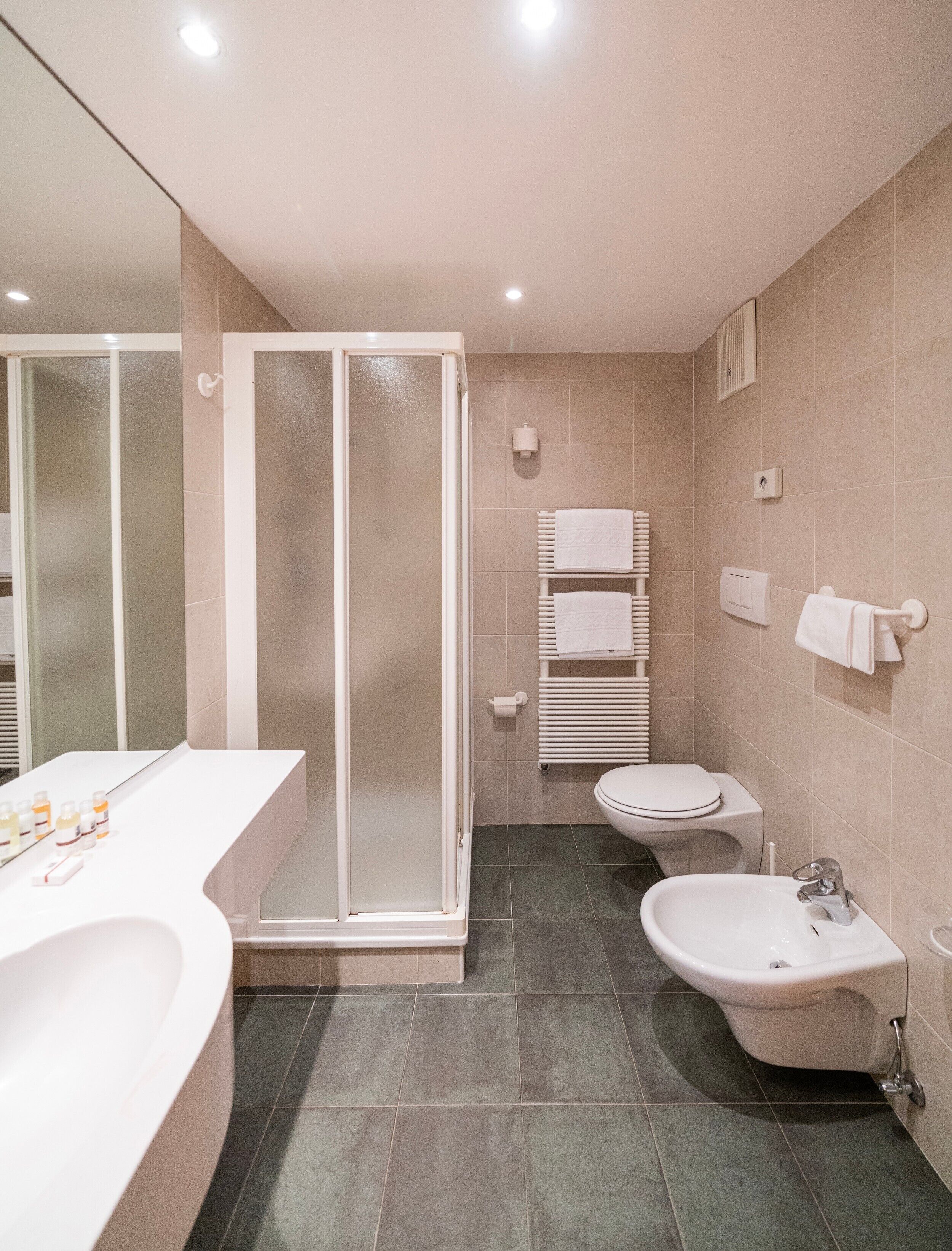 Ein modernes Badezimmer mit Duschkabine, Toilette, Bidet und einer großen Badewanne.
