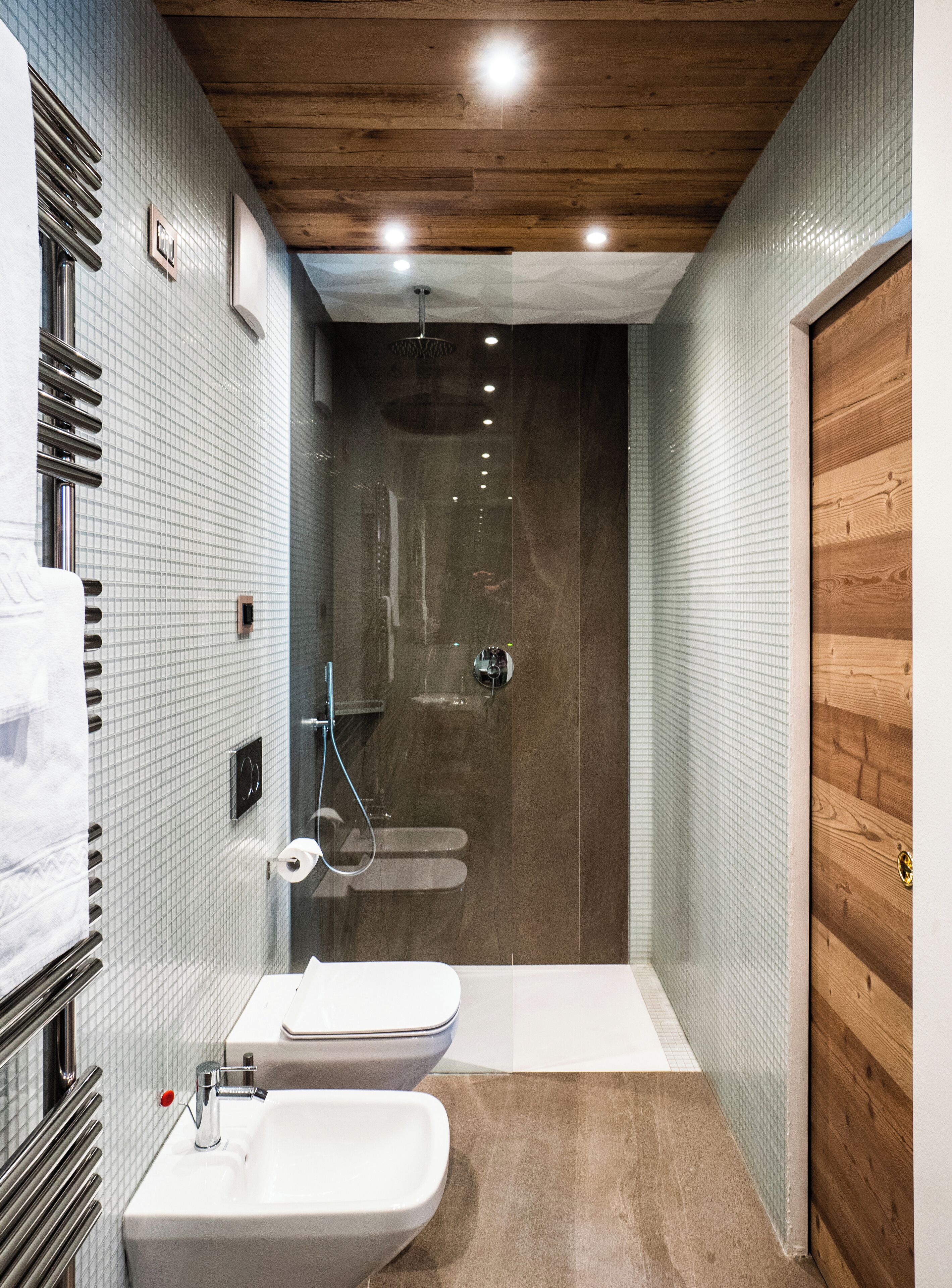 Une salle de bain moderne avec une douche, deux lavabos et un plafond en bois.