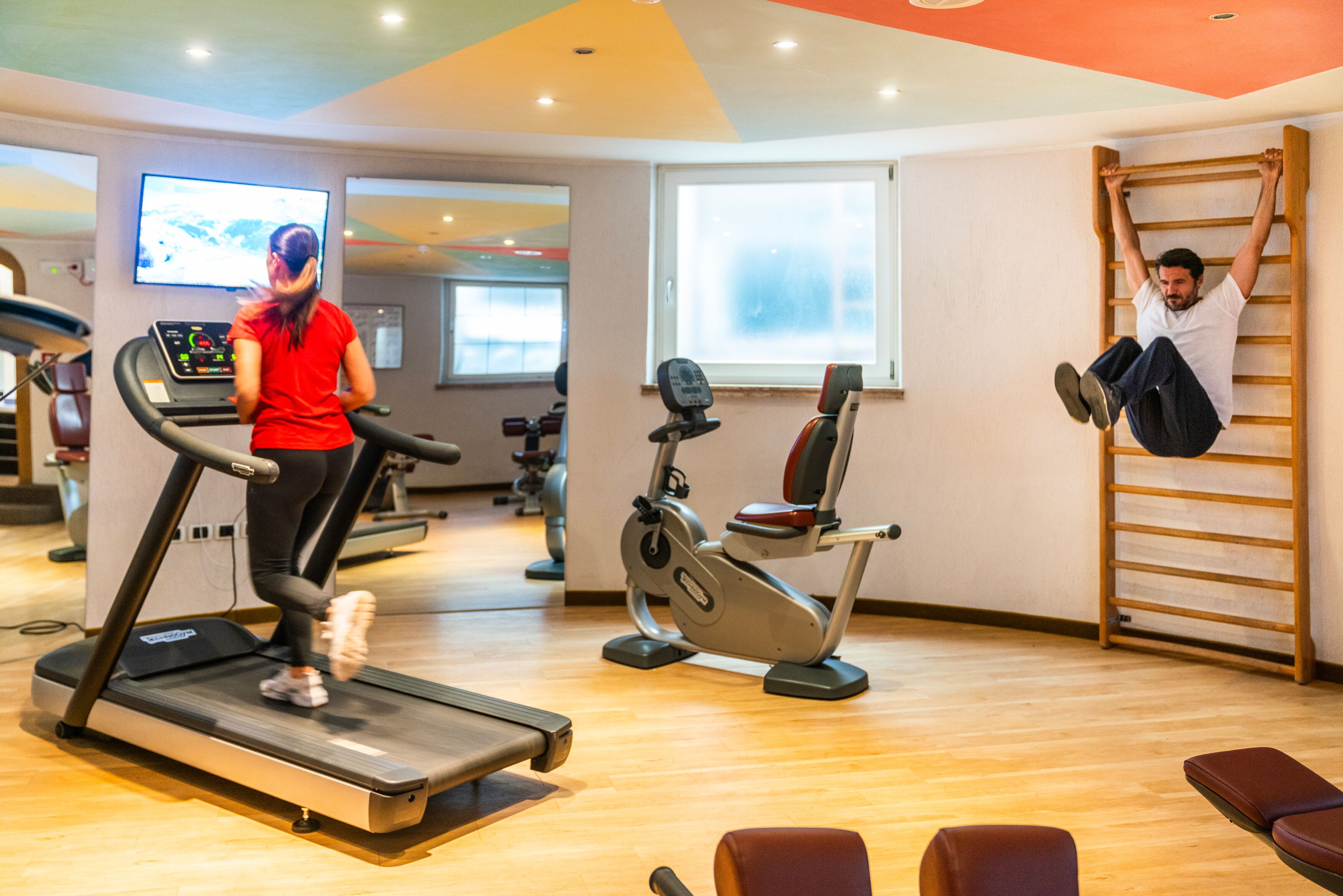 A gym with treadmills, stationary bikes, and a pull-up bar.