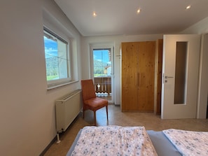A bedroom with a bed, a chair, a wardrobe, and a radiator. - Haus Schönberg (Leutasch)