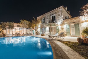 A stone building with a swimming pool, outdoor seating, and potted plants. - Panjur Alacati (Cesme)