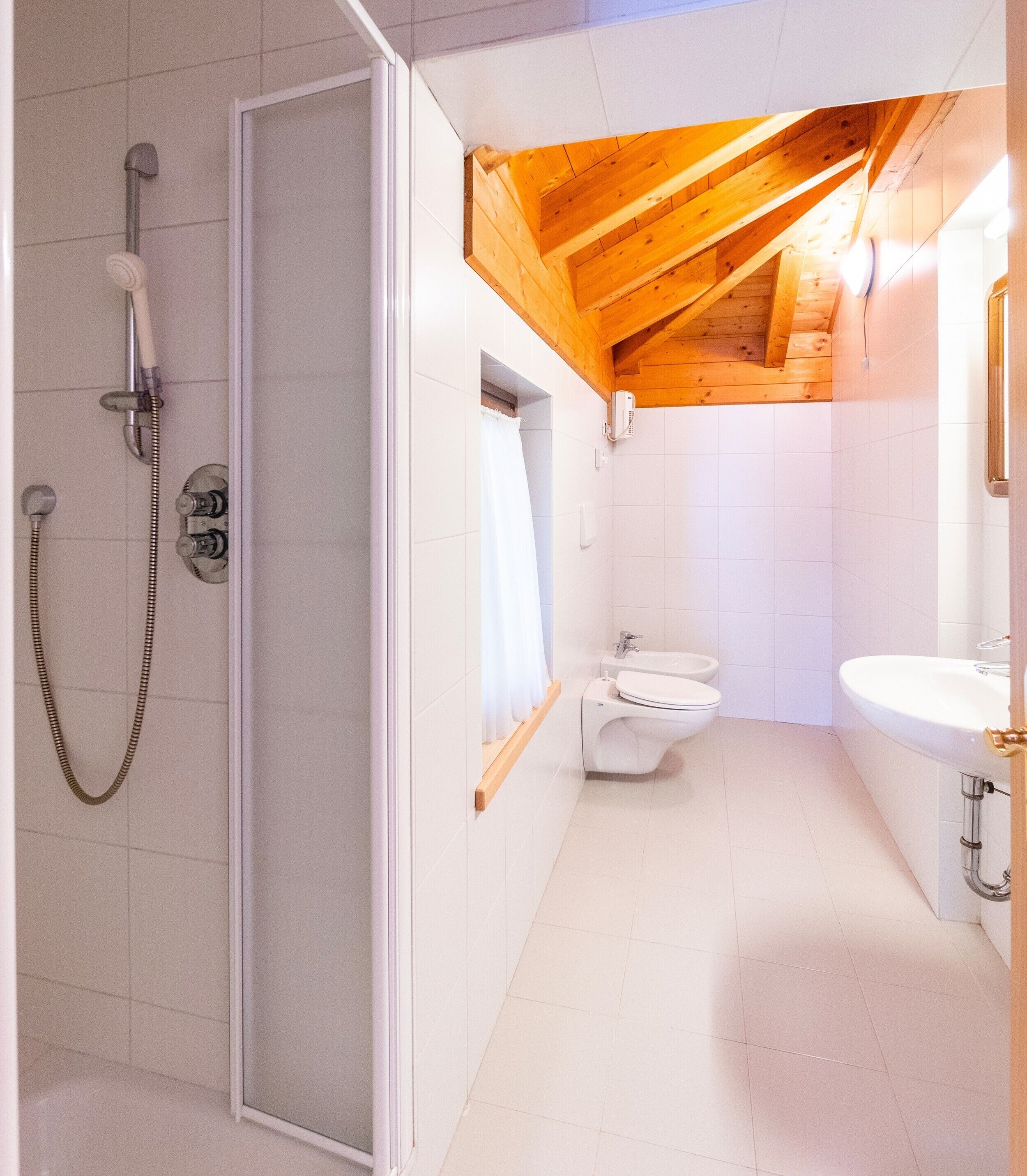 Une salle de bain avec douche, toilettes et lavabo.