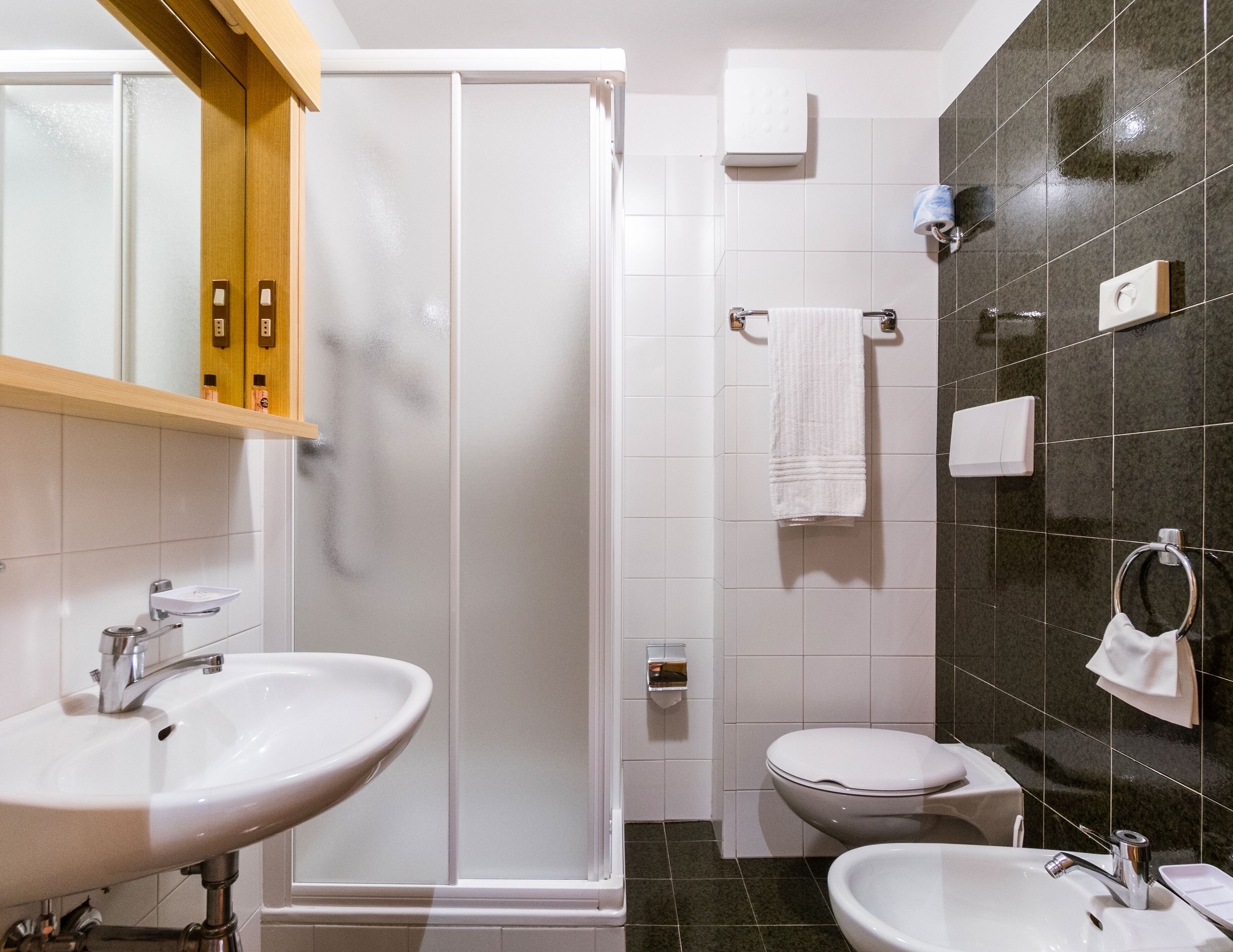 Une salle de bain avec deux lavabos, des toilettes, une douche et un miroir.