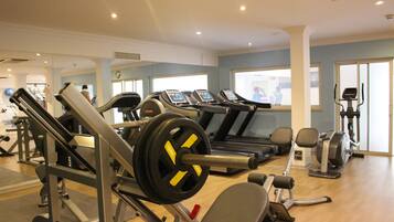 A gym with cardio machines, weightlifting equipment, and a treadmill.