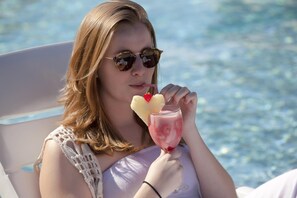 A person sitting by a pool with a drink in hand. - Tabaobí Smart Hotel (Ipojuca)