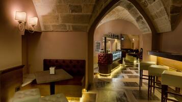 A cozy interior with a stone archway, a bar area, and seating arrangements.