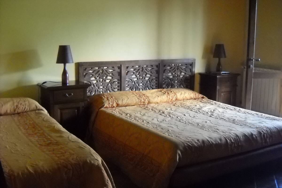 Un lit double avec une tête de lit, une table de chevet et une lampe.