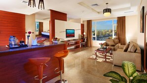 A modern living room with a large TV, a bar area, and a sofa. - Best Western Plus Salmiya (Salmiya)