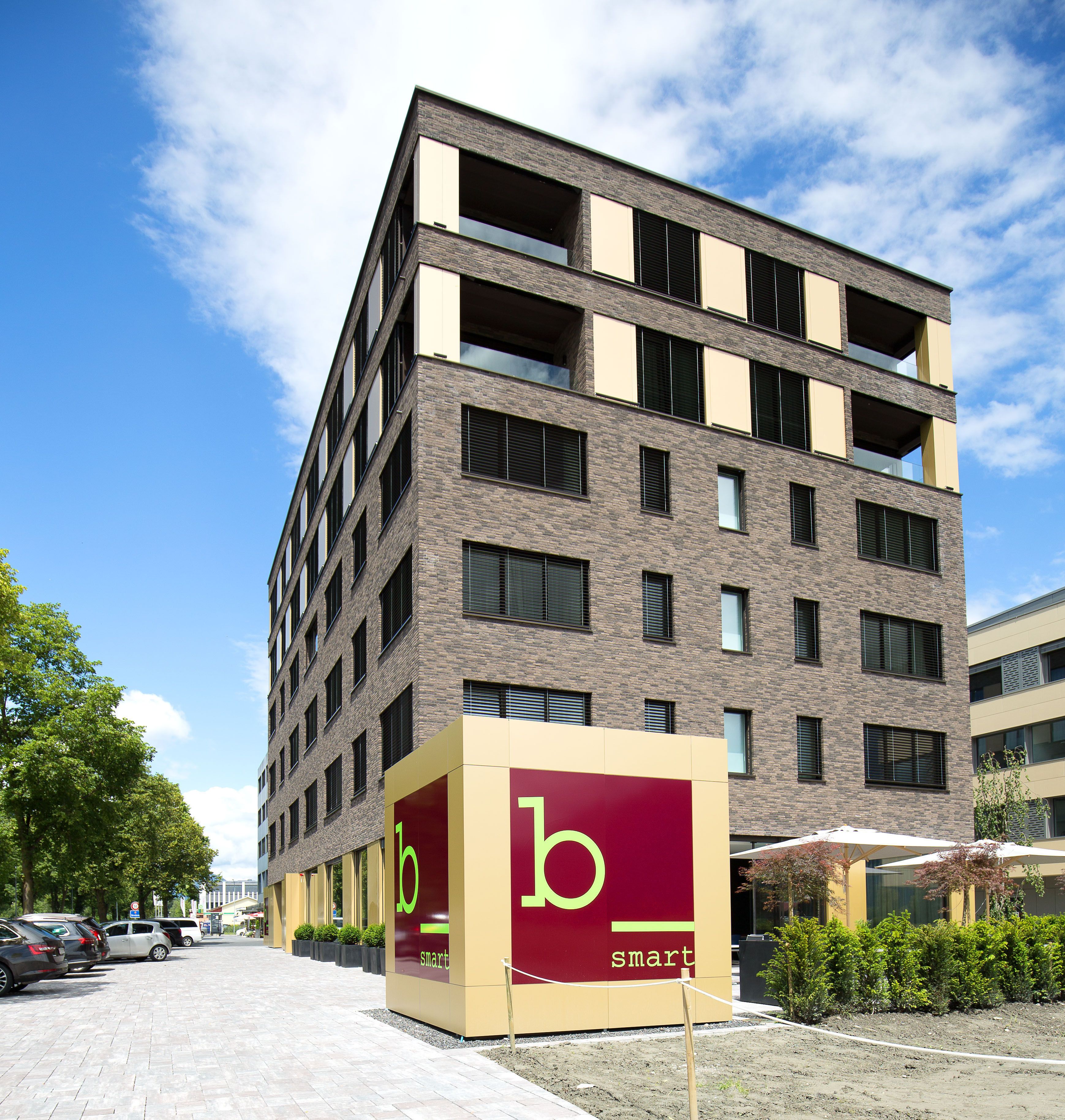 Een modern meerlaags gebouw met een opvallend 'b smart' bord aan de gevel.