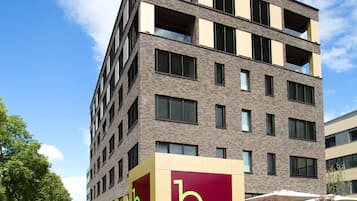 Un edificio moderno de varios pisos con un llamativo letrero 'b smart' en la fachada.
