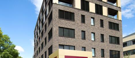 Un edificio moderno de varios pisos con un llamativo letrero 'b smart' en la fachada.