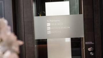 A glass door with a sign listing amenities: fitness & well, service station, and parking.