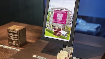 A digital display with a QR code, a check-out box, and a sign for room cards.