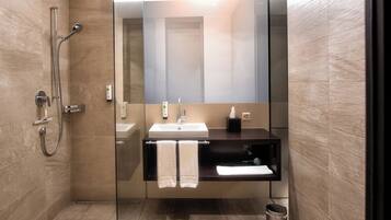 A modern bathroom with a glass shower enclosure, a sink, and a mirror.