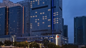 Un hotel de gran altura con un llamativo logotipo de Marriott, varios pisos y fachada de vidrio moderna.