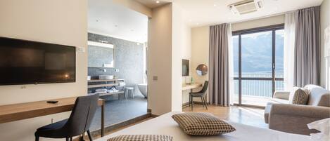 Une chambre d’hôtel moderne dotée d’un grand lit, d’une télévision, d’un bureau et d’un balcon avec vue.