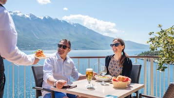Una pareja cenando en una mesa con vistas panorámicas a la montaña.