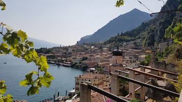 A coastal town with historic buildings, a waterfront promenade, and a mountain in the background.