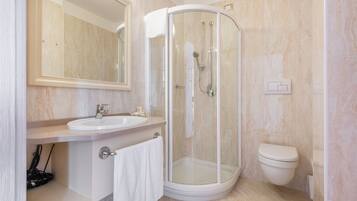 Ein modernes Badezimmer mit einer Glasdusche, einem Waschbecken und einer Toilette.