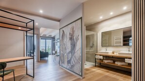 Une salle de bain moderne avec un grand miroir, un revêtement de sol en bois et un espace douche.