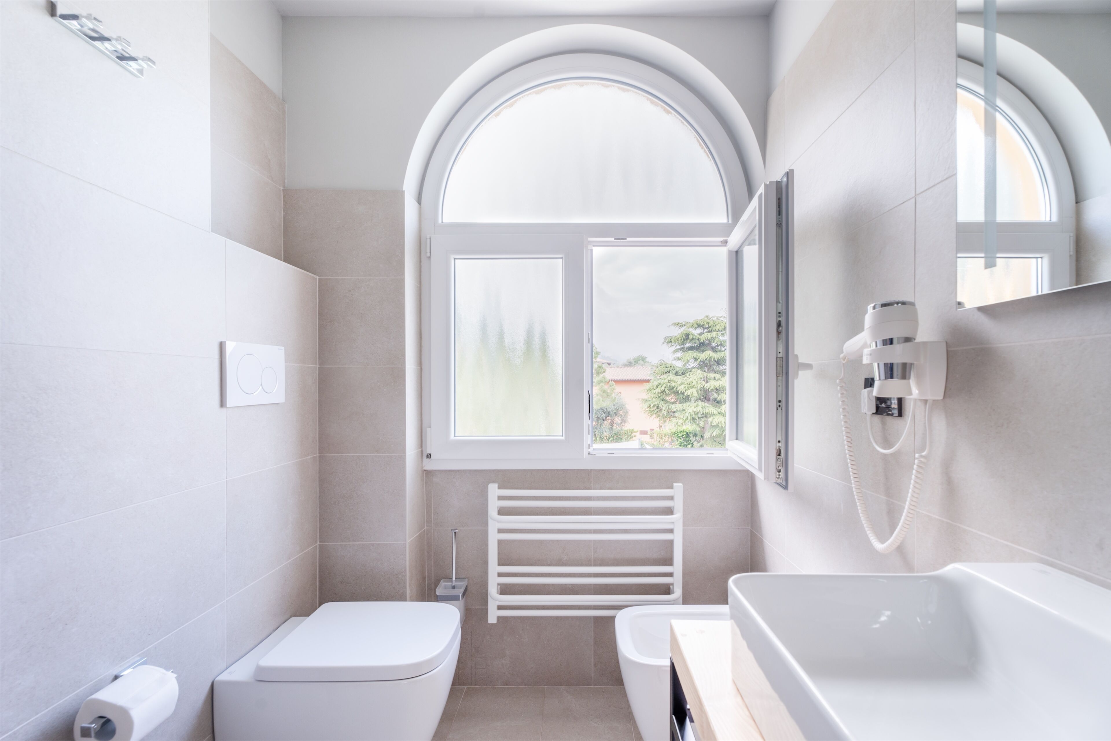 Un baño moderno con inodoro, lavamanos y ducha.