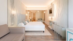 Une chambre d’hôtel moderne équipée d’un grand lit, d’un canapé, d’un bureau et d’une télévision.