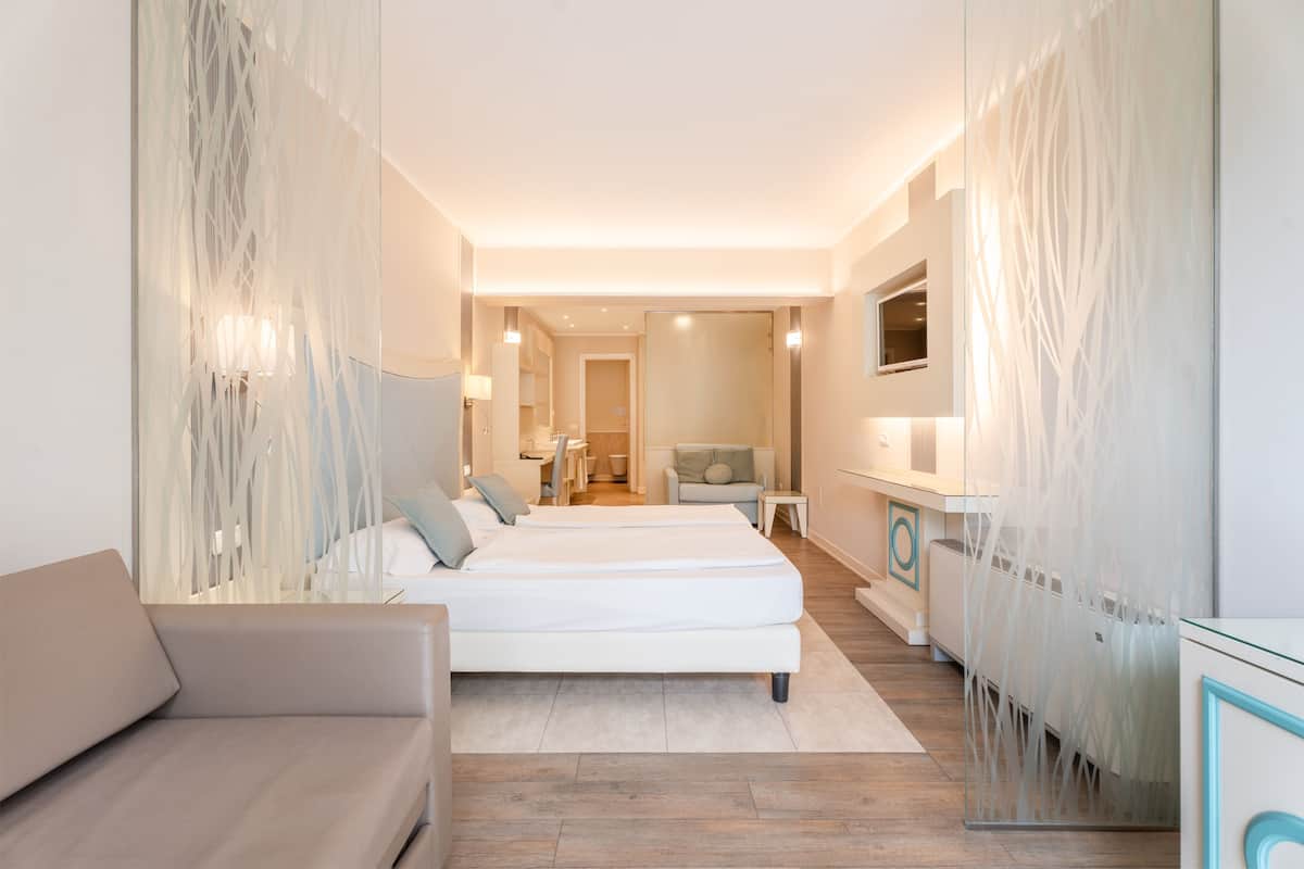 Une chambre d’hôtel moderne équipée d’un grand lit, d’un canapé, d’un bureau et d’une télévision.