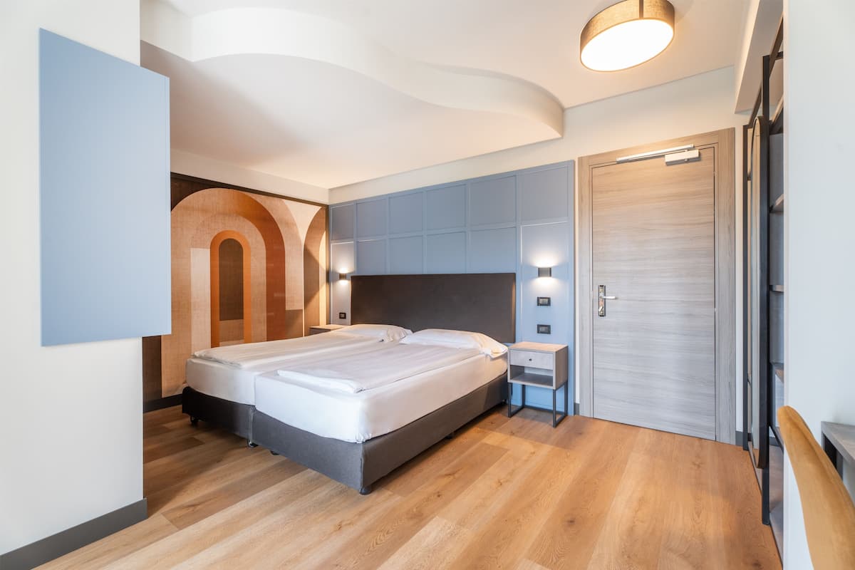 Une chambre moderne avec un grand lit, des étagères intégrées et une porte en bois.