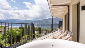 Un balcon avec vue sur les montagnes et un lac.