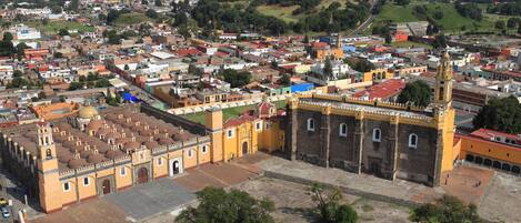A historic building with a prominent bell tower and a large courtyard.