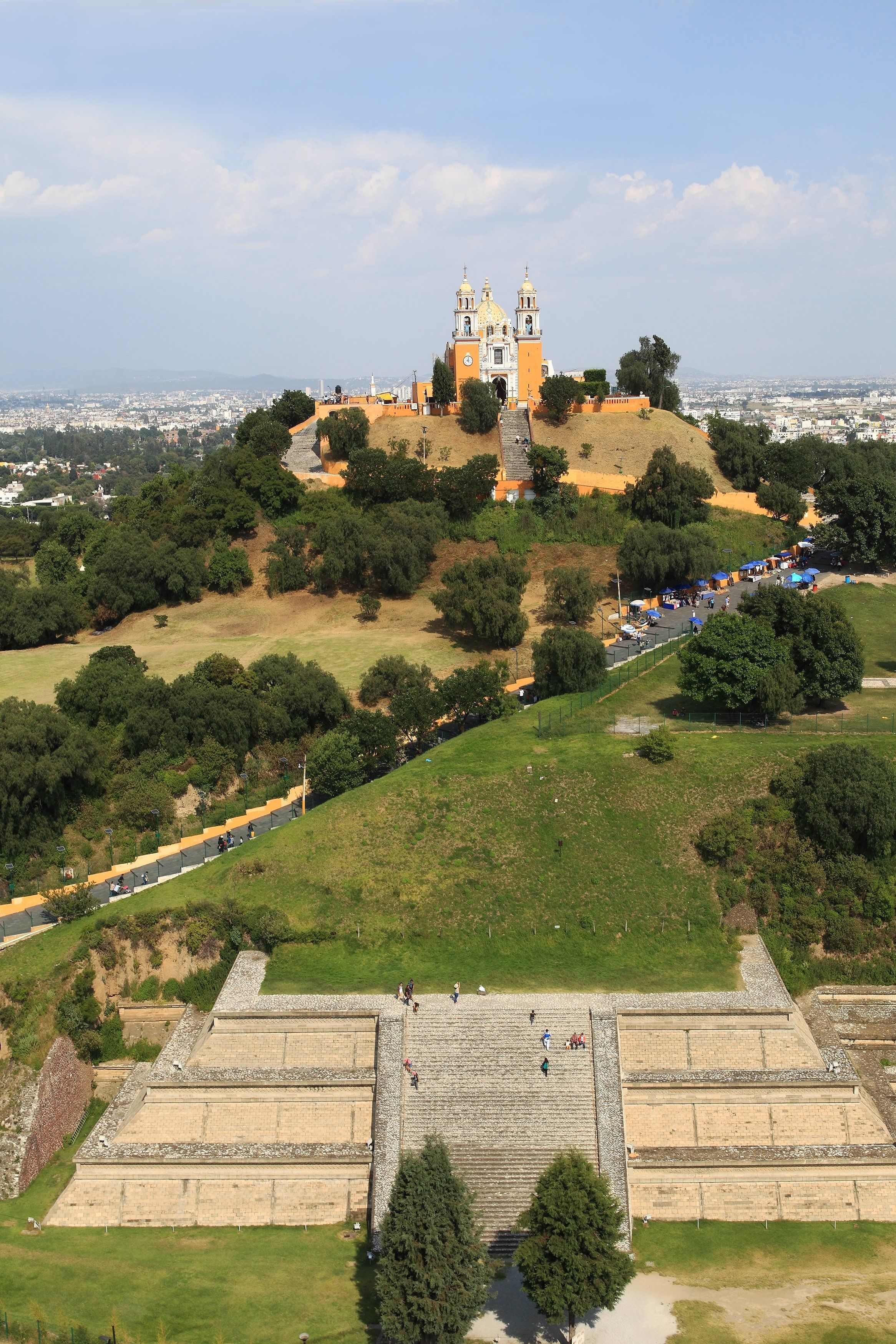A historical site with a prominent church on a hill, a large open plaza, and a fortified structure in the foreground.