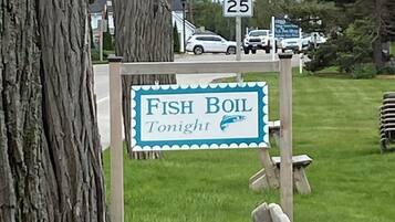 A sign for "Fish Boil Tonight" with a speed limit sign above it.