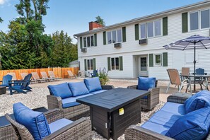An outdoor patio area with wicker furniture, a table, and chairs.