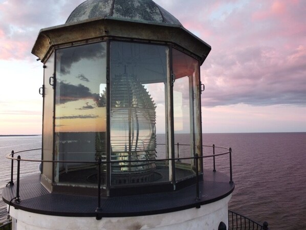 A lighthouse with a glass enclosure, a metal railing, and a view of the sea. - Wilder Inn (Ephraim)