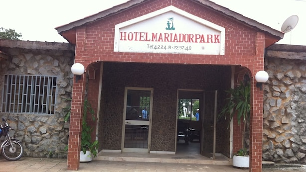 Entrada de un hotel con un letrero que dice "HOTEL MARIADORPARK" y un número de contacto.