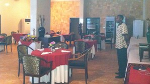 Un restaurante con varias mesas, sillas y un ventilador de techo.