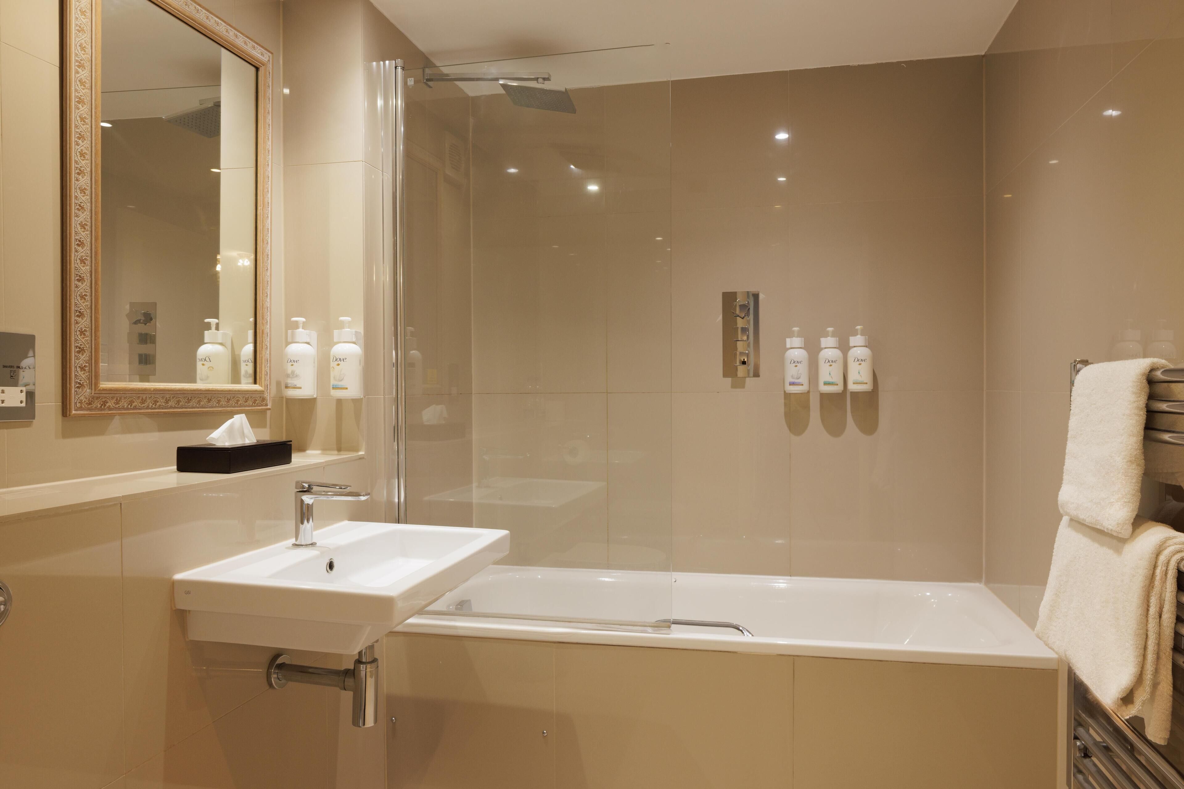 A modern bathroom with a glass-enclosed shower, a sink, and a bathtub.