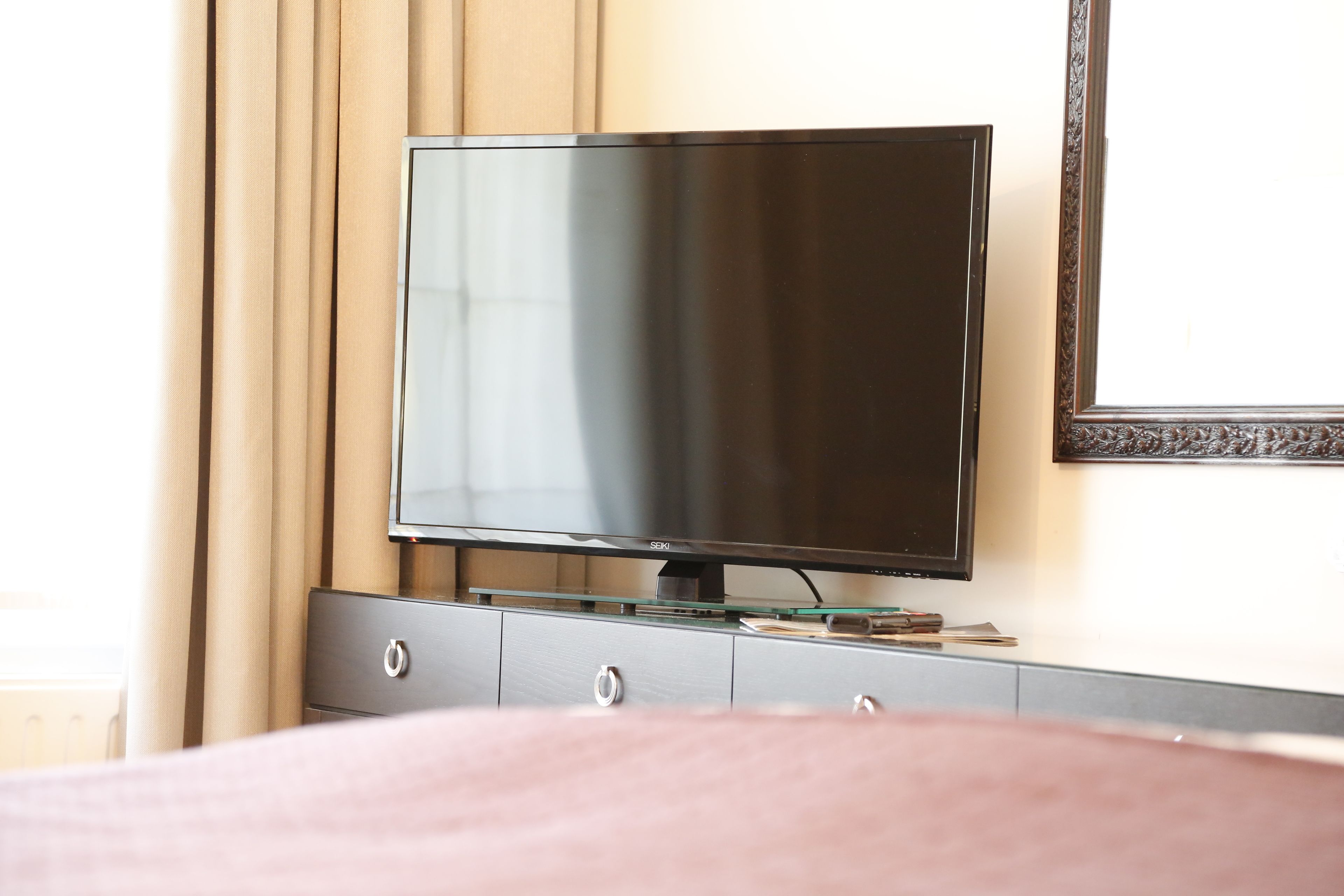 A television on a dresser in a hotel room.