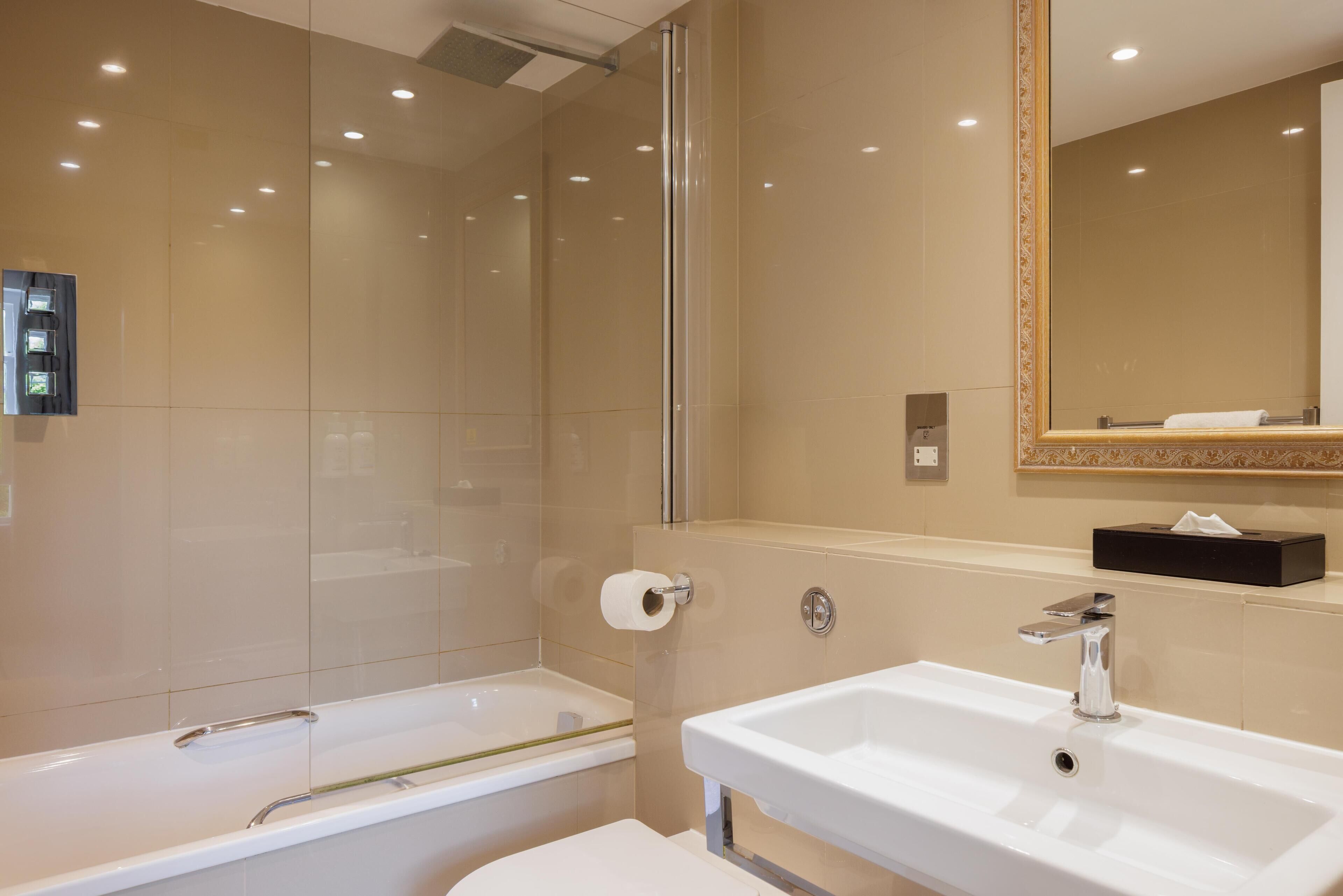 A modern bathroom with a bathtub, a sink, and a mirror.