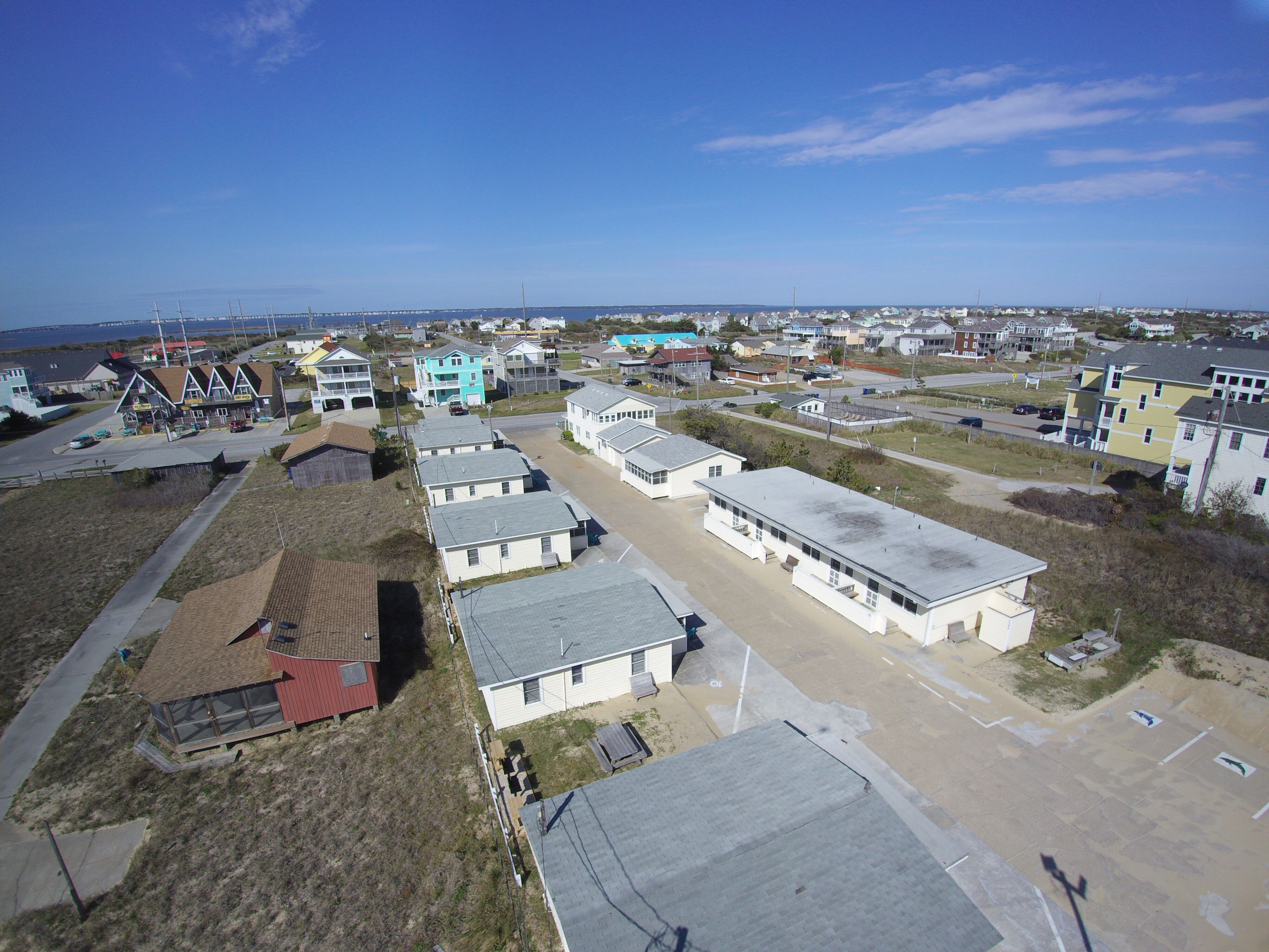 A residential area with houses, a road, and a bridge in the background.