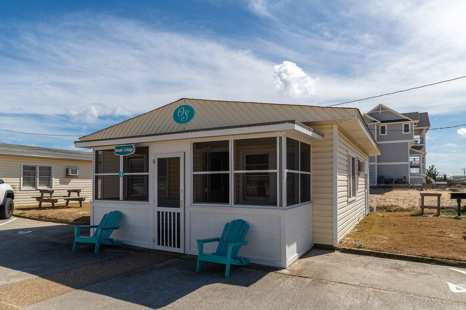 Un petit bâtiment d’un seul étage, doté d’un porche, de deux chaises et d’une enseigne indiquant « Bosun’s Cottage ».